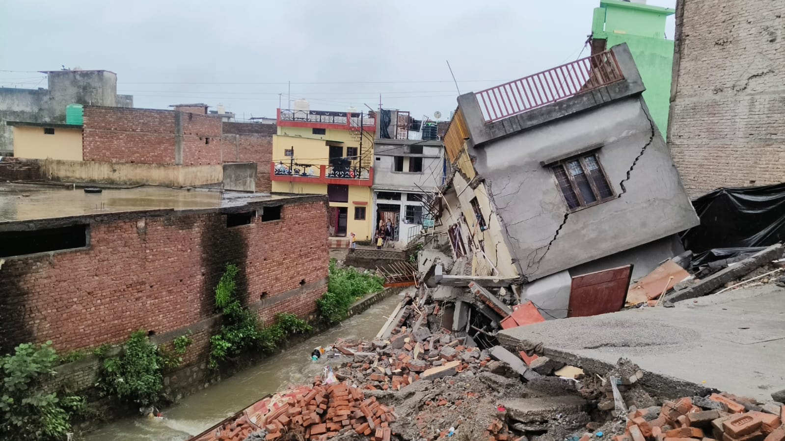 बरसात बरपा रही कहर, कारगी ग्रांट क्षेत्र में नदी किनारे बने दो मकान गिरे